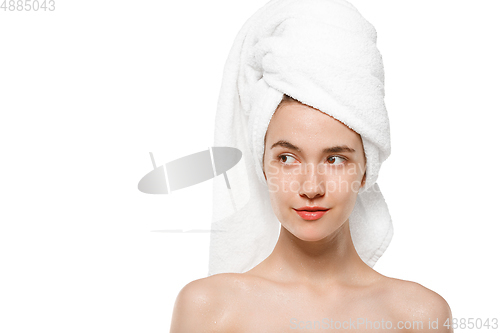 Image of Beauty Day. Woman wearing towel doing her daily skincare routine isolated on white studio background