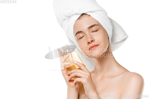 Image of Beauty Day. Woman wearing towel doing her daily skincare routine isolated on white studio background