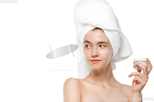 Image of Beauty Day. Woman wearing towel doing her daily skincare routine isolated on white studio background