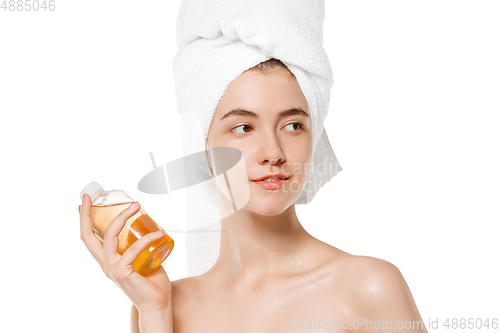 Image of Beauty Day. Woman wearing towel doing her daily skincare routine isolated on white studio background