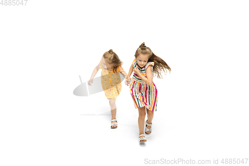 Image of Happy little caucasian girls jumping and running isolated on white background