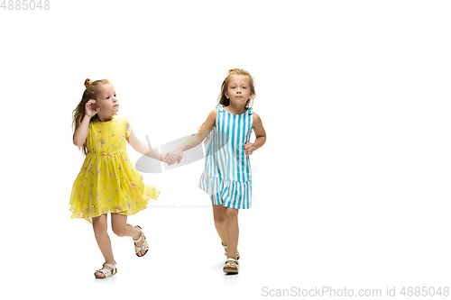 Image of Happy little caucasian girls jumping and running isolated on white background