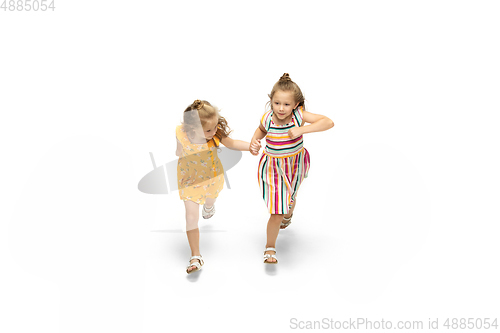 Image of Happy little caucasian girls jumping and running isolated on white background