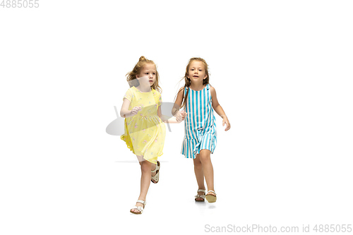 Image of Happy little caucasian girls jumping and running isolated on white background