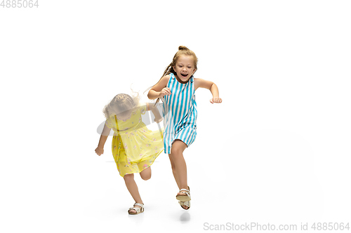 Image of Happy little caucasian girls jumping and running isolated on white background
