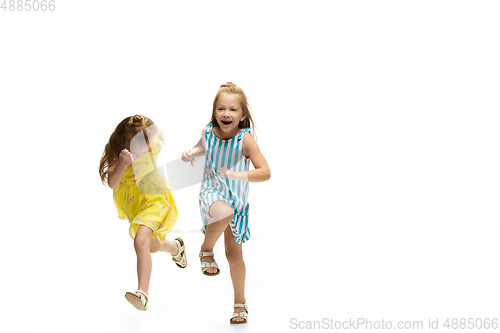 Image of Happy little caucasian girls jumping and running isolated on white background