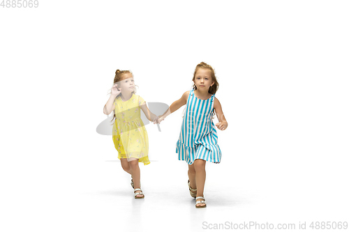 Image of Happy little caucasian girls jumping and running isolated on white background
