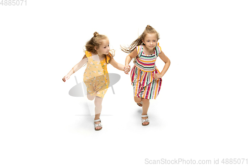 Image of Happy little caucasian girls jumping and running isolated on white background