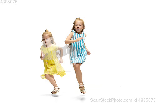 Image of Happy little caucasian girls jumping and running isolated on white background