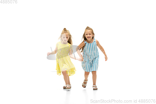 Image of Happy little caucasian girls jumping and running isolated on white background