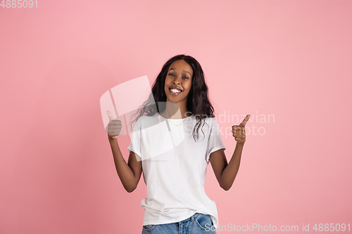 Image of Cheerful african-american young woman isolated on pink background, emotional and expressive
