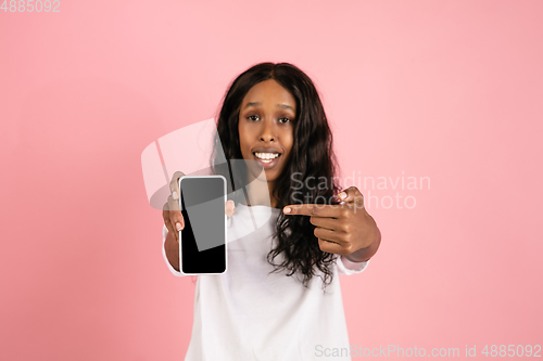 Image of Cheerful african-american young woman isolated on pink background, emotional and expressive