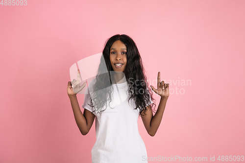 Image of Cheerful african-american young woman isolated on pink background, emotional and expressive