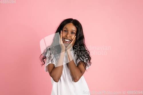 Image of Cheerful african-american young woman isolated on pink background, emotional and expressive