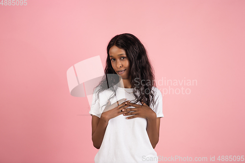 Image of Cheerful african-american young woman isolated on pink background, emotional and expressive