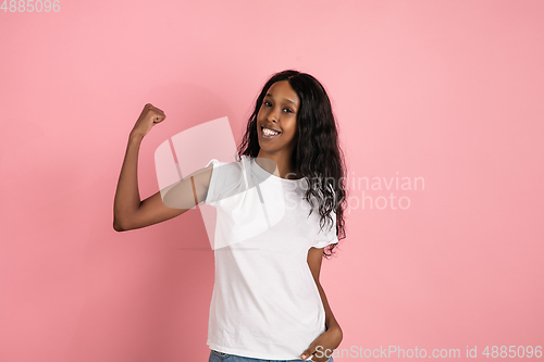 Image of Cheerful african-american young woman isolated on pink background, emotional and expressive