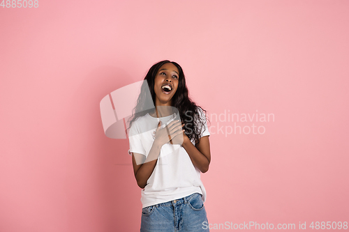 Image of Cheerful african-american young woman isolated on pink background, emotional and expressive