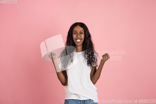 Image of Cheerful african-american young woman isolated on pink background, emotional and expressive