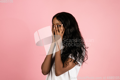 Image of Cheerful african-american young woman isolated on pink background, emotional and expressive