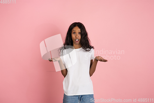 Image of Cheerful african-american young woman isolated on pink background, emotional and expressive