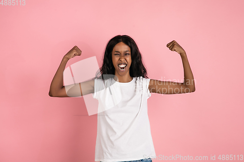 Image of Cheerful african-american young woman isolated on pink background, emotional and expressive