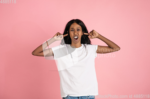 Image of Cheerful african-american young woman isolated on pink background, emotional and expressive