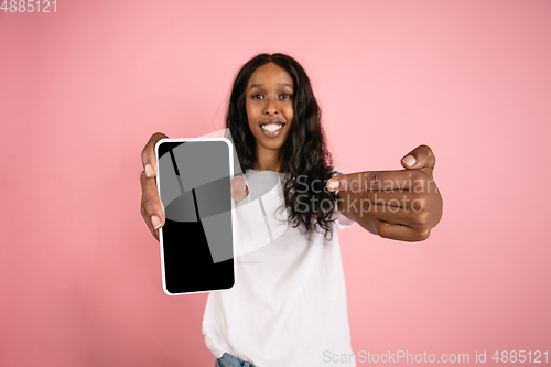 Image of Cheerful african-american young woman isolated on pink background, emotional and expressive