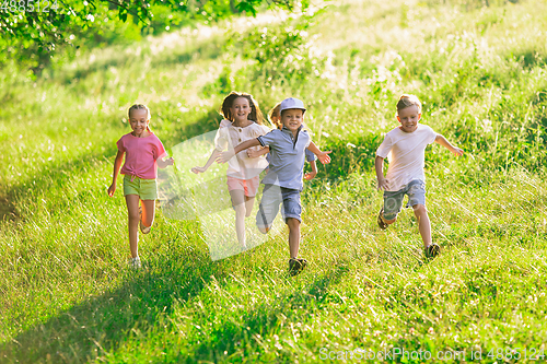 Image of Kids, children running on meadow in summer\'s sunlight