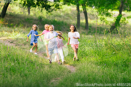 Image of Kids, children running on meadow in summer\'s sunlight