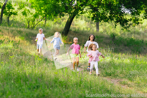 Image of Kids, children running on meadow in summer\'s sunlight