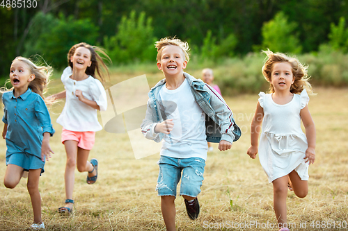 Image of Kids, children running on meadow in summer\'s sunlight