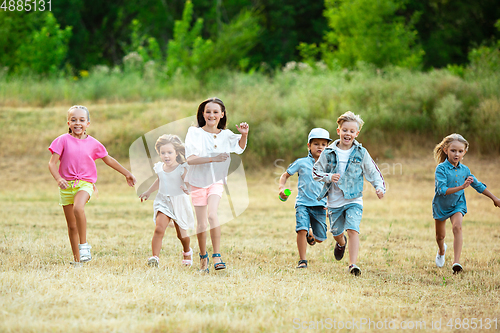 Image of Kids, children running on meadow in summer\'s sunlight