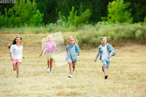 Image of Kids, children running on meadow in summer\'s sunlight