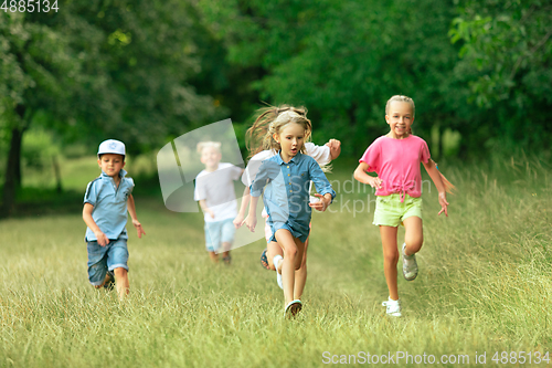 Image of Kids, children running on meadow in summer\'s sunlight