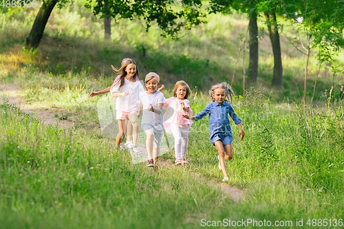 Image of Kids, children running on meadow in summer\'s sunlight