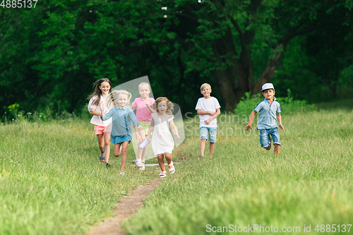 Image of Kids, children running on meadow in summer\'s sunlight