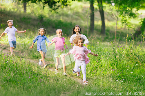 Image of Kids, children running on meadow in summer\'s sunlight