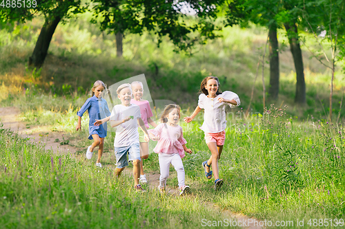 Image of Kids, children running on meadow in summer\'s sunlight