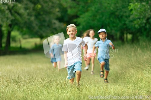 Image of Kids, children running on meadow in summer\'s sunlight