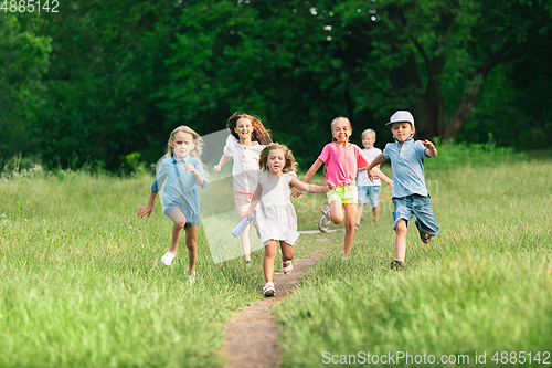 Image of Kids, children running on meadow in summer\'s sunlight