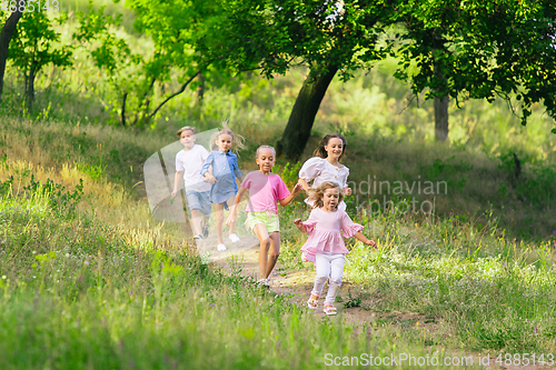 Image of Kids, children running on meadow in summer\'s sunlight