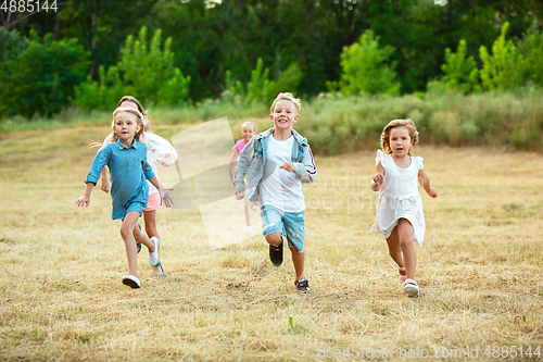 Image of Kids, children running on meadow in summer\'s sunlight