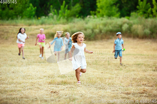 Image of Kids, children running on meadow in summer\'s sunlight