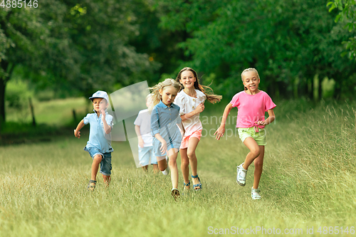 Image of Kids, children running on meadow in summer\'s sunlight