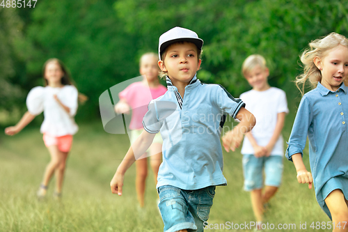 Image of Kids, children running on meadow in summer\'s sunlight