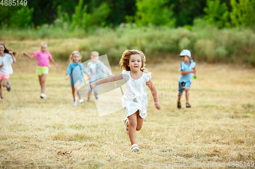 Image of Kids, children running on meadow in summer\'s sunlight