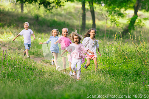 Image of Kids, children running on meadow in summer\'s sunlight
