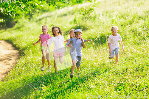 Image of Kids, children running on meadow in summer\'s sunlight