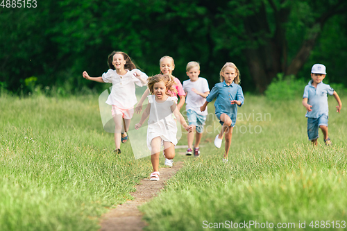 Image of Kids, children running on meadow in summer\'s sunlight