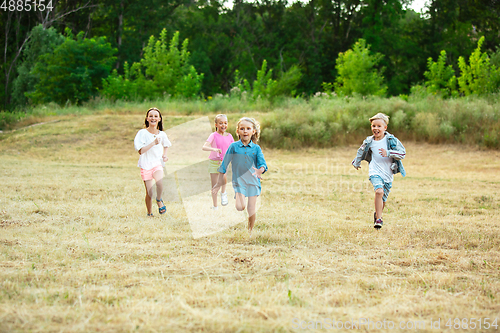 Image of Kids, children running on meadow in summer\'s sunlight